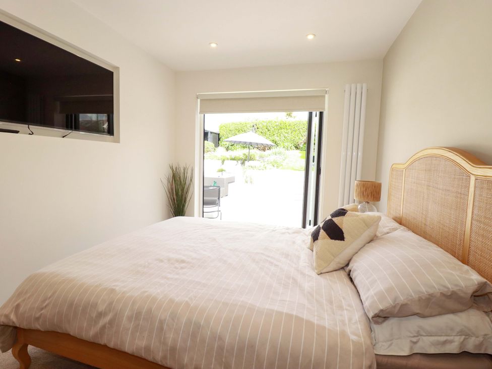 A bedroom with a bed and television at No.45 Whealgolden Drive in Newquay