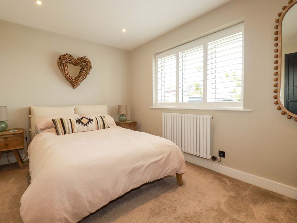 A bedroom with a bed and bedside tables at No.45 Whealgolden Drive Newquay