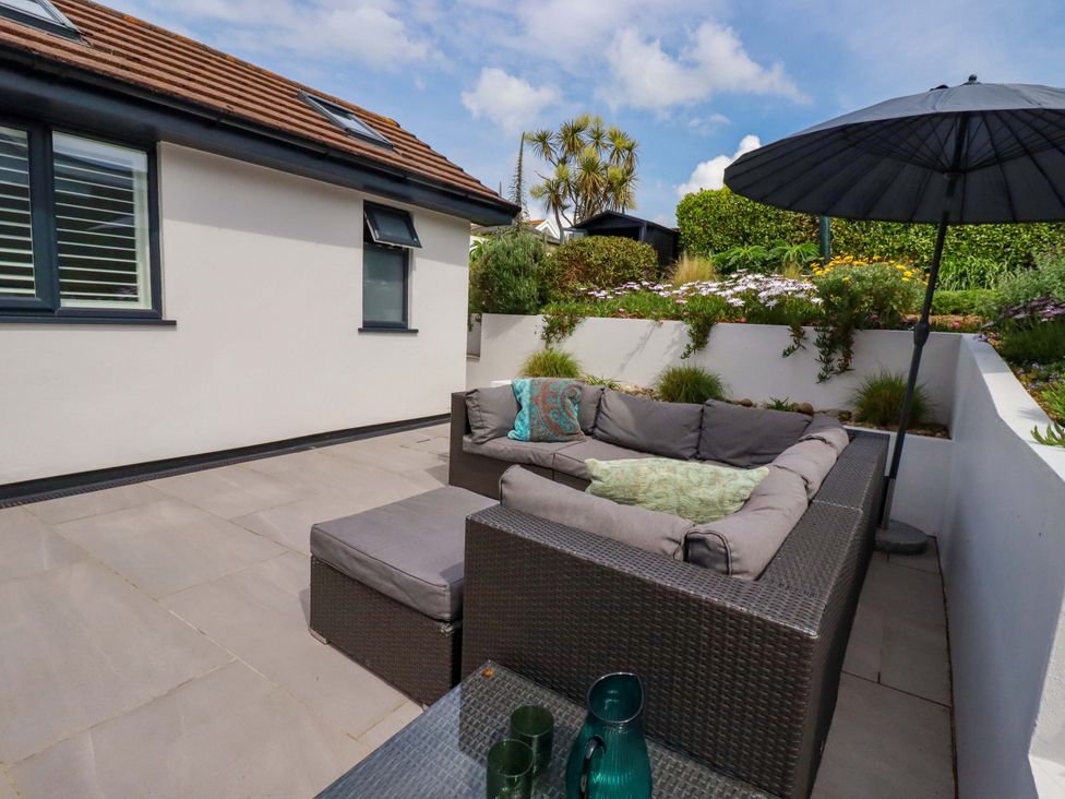 An outdoor area with a sofa and an umbrella at No.45 Whealgolden Drive in Newquay