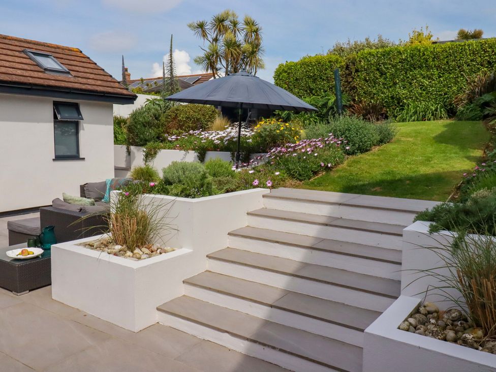 A garden with stairs and seating area at No.45 Whealgolden Drive Newquay