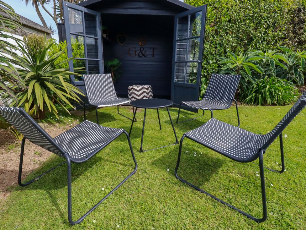 A garden area with chairs and a table at No.45 Whealgolden Drive in Newquay