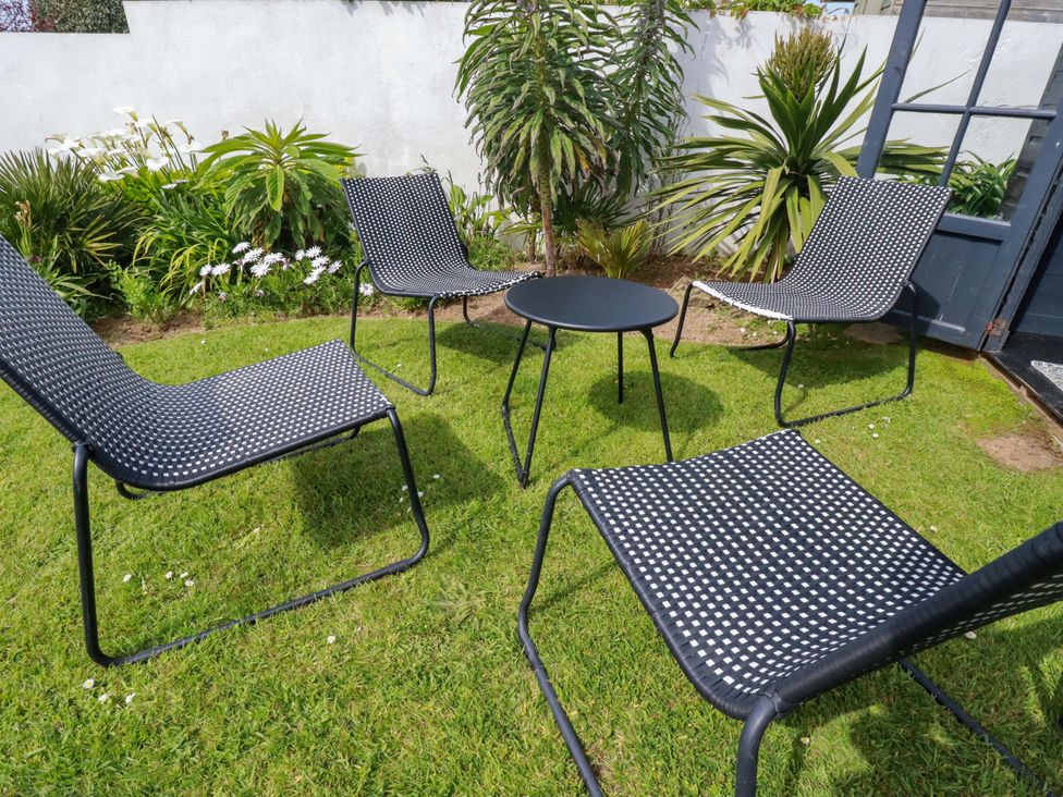 A garden with four chairs and a table at No.45 Whealgolden Drive Newquay