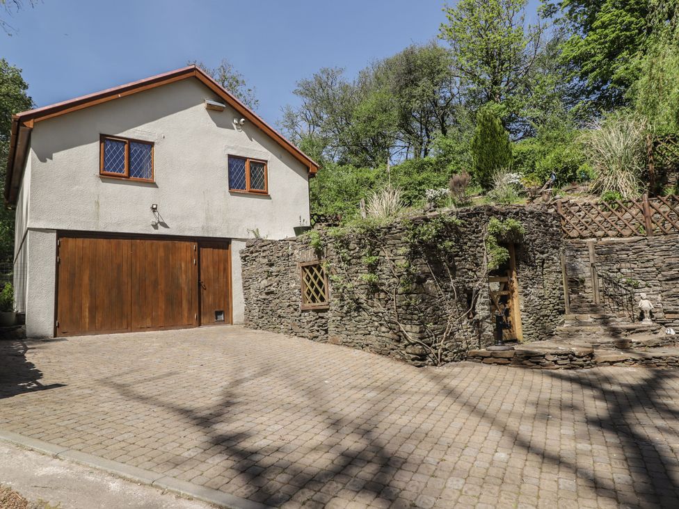 A house with garage and stone wall at Cân adar in Llangeinor