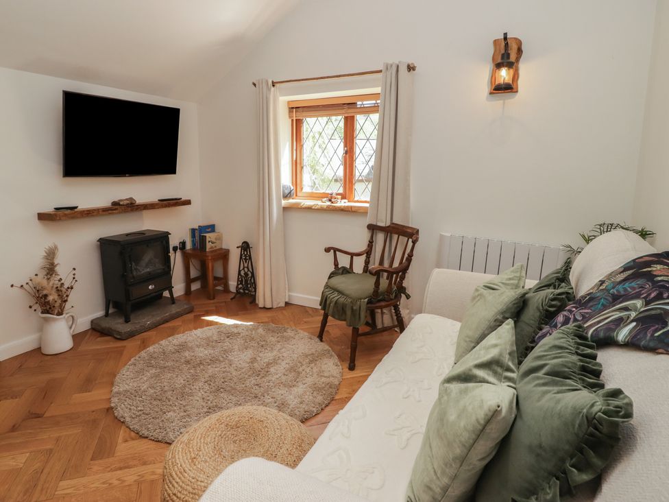 A living room with a window and a wood stove at Cân adar in Llangeinor