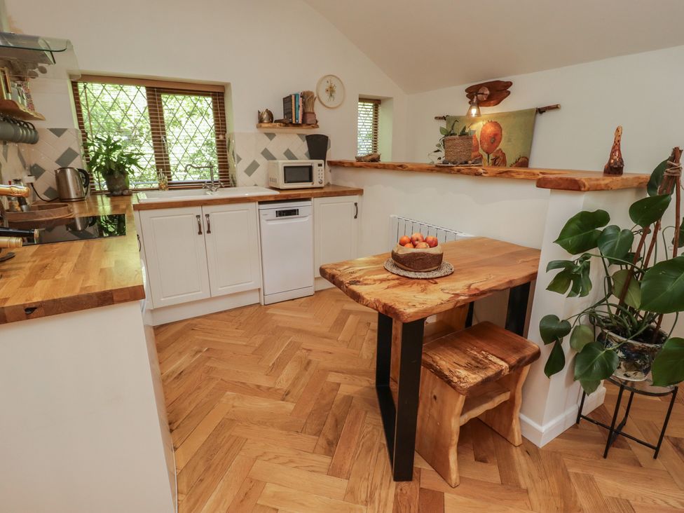 A kitchen with a table and chairs at Cân adar in Llangeinor