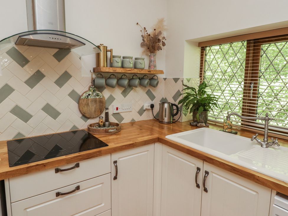 A kitchen with a sink and kettle at Cân adar in Llangeinor