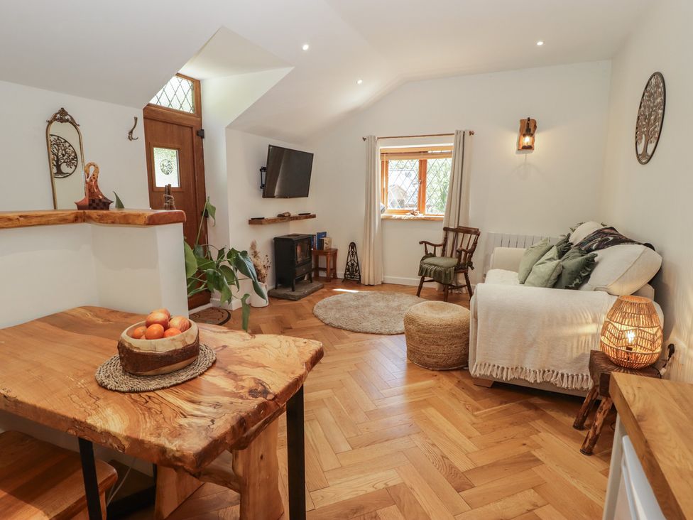 A living room with a sofa and a table at Cân adar in Llangeinor