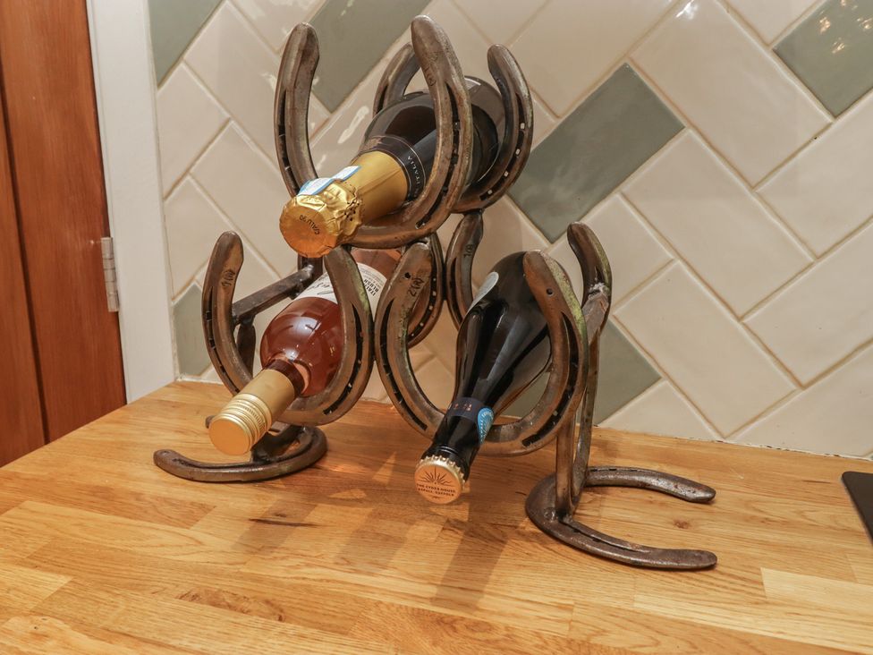 A wine rack displaying three bottles of wine at Cân adar in Llangeinor