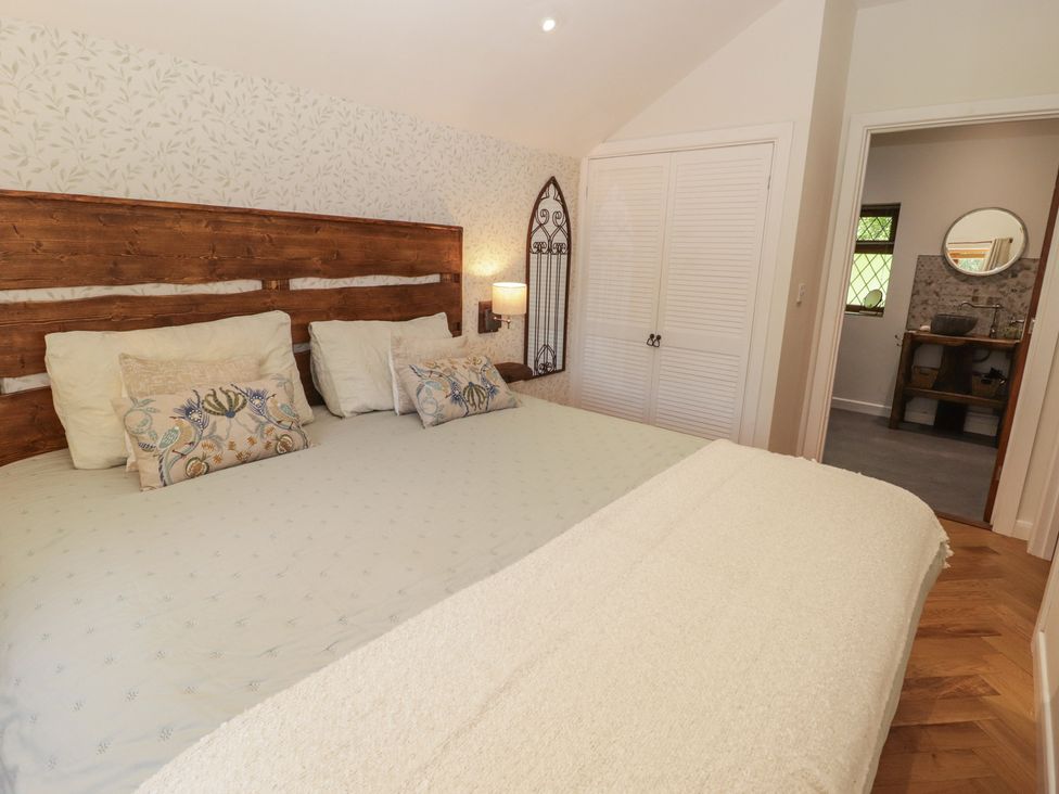A bedroom with a bed and wardrobe at Cân adar in Llangeinor
