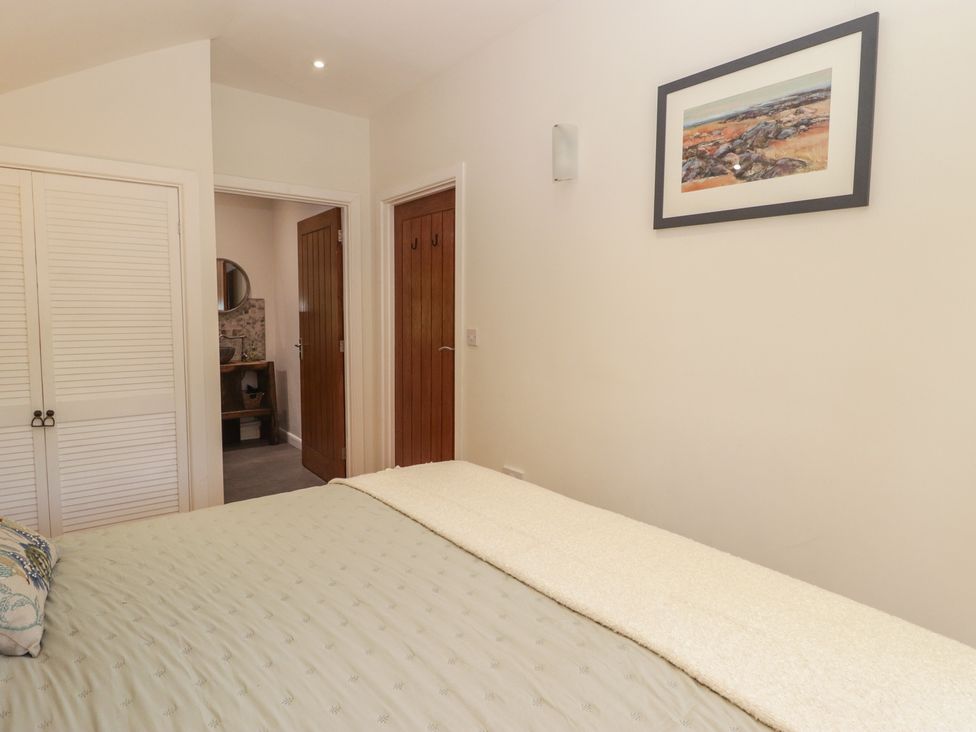 A bedroom with a bed and wardrobe at Cân adar Llangeinor