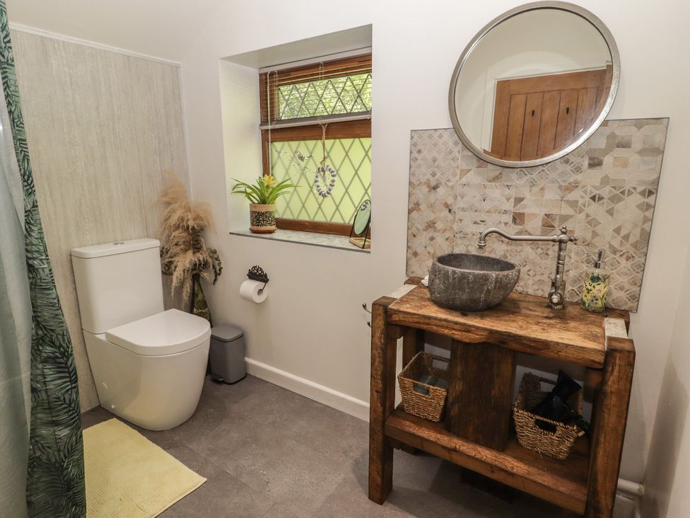 A bathroom with a toilet and a wooden sink at Cân adar in Llangeinor