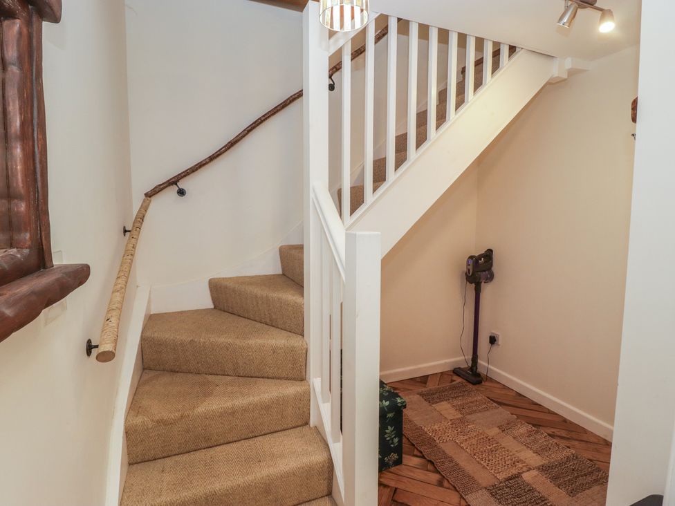 A hallway with stairs and a vacuum cleaner at Cân adar in Llangeinor