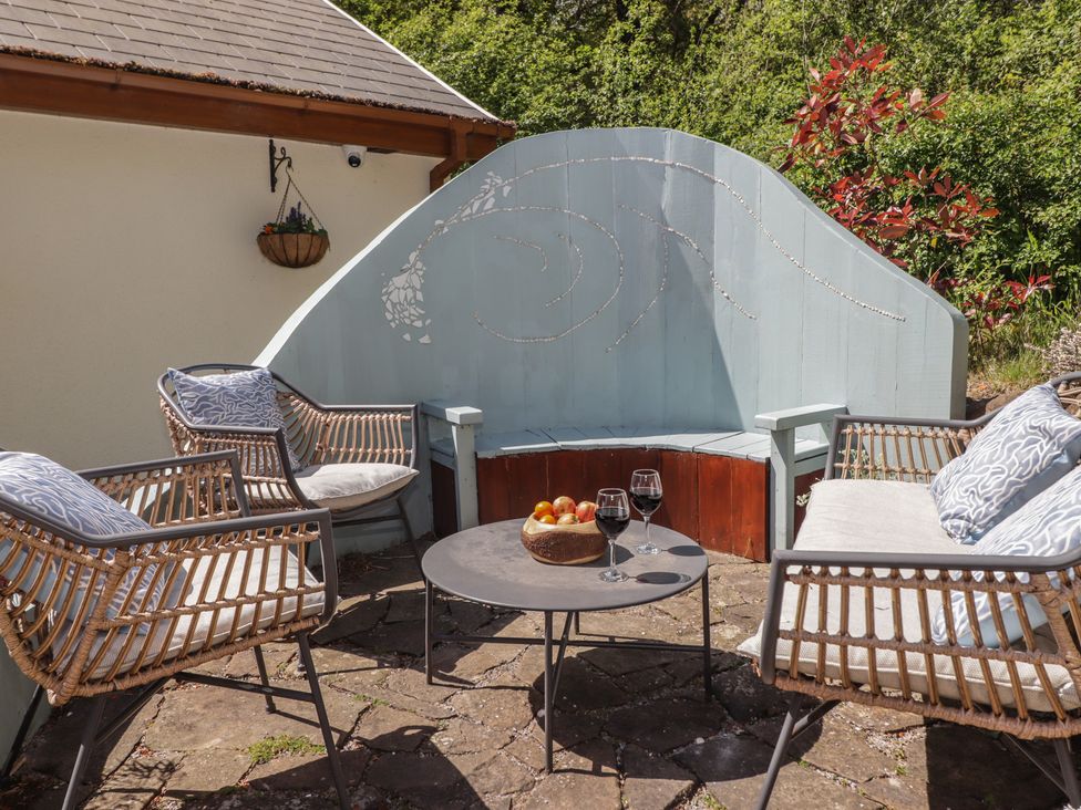 An outdoor seating area with chairs and a table at Cân adar in Llangeinor