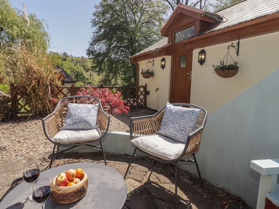 A seating area with chairs and a table outside at Cân adar in Llangeinor