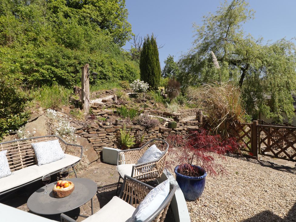 A garden with a sitting area and plants at Cân adar in Llangeinor
