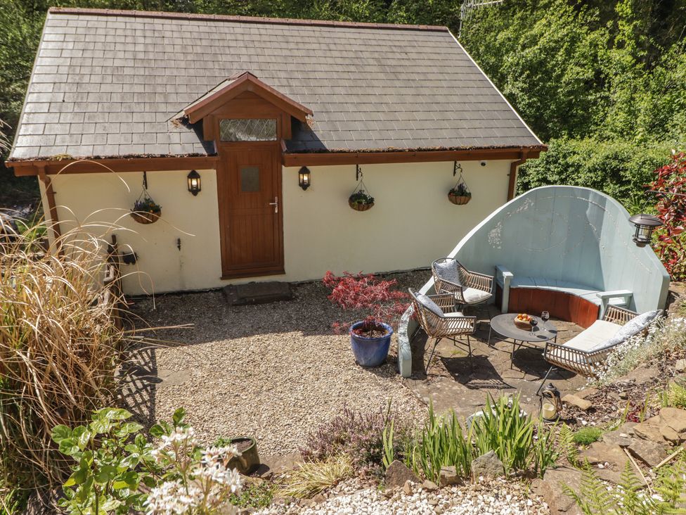 A cabin with seating area and plants at Cân adar in Llangeinor