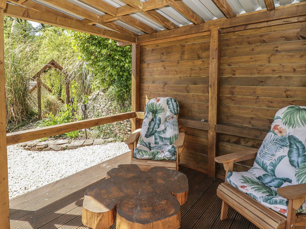 An outdoor seating area with two chairs and a round table at Cân adar in Llangeinor