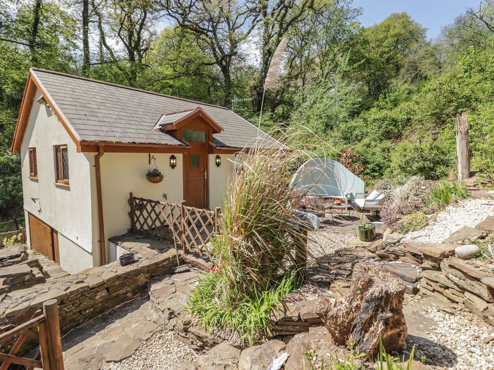A house with a garden and seating area at Cân adar in Llangeinor