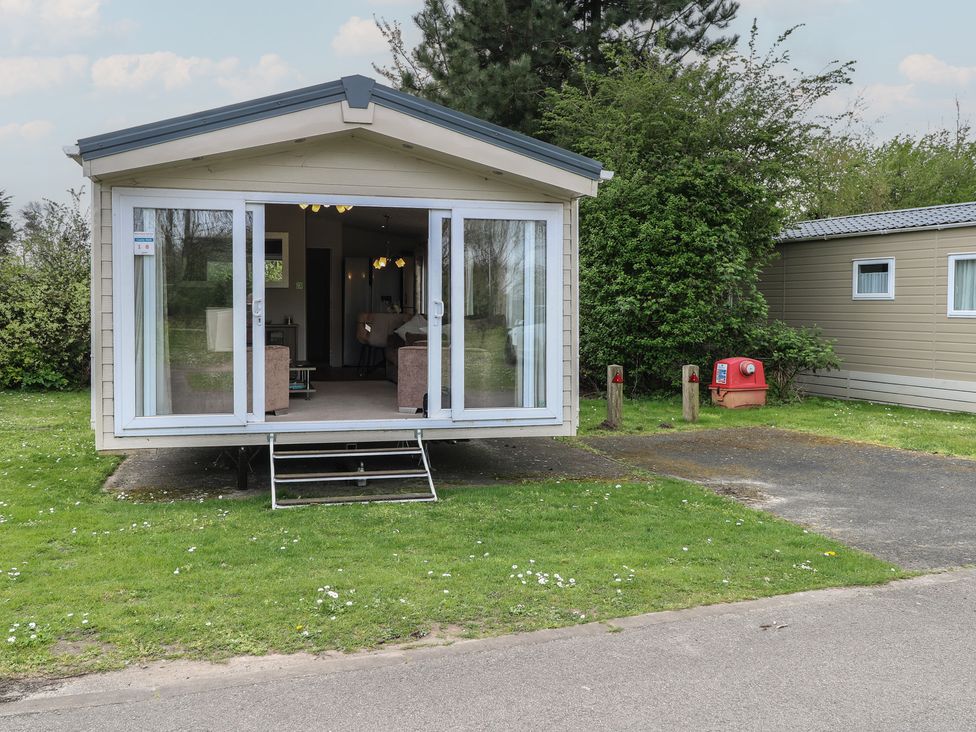 A mobile home with steps and windows at The Norfolk Nook 18 Castle Walk Burgh Castle