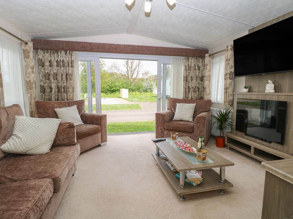 A living room with a sofa and coffee table at The Norfolk Nook 18 Castle Walk Burgh Castle