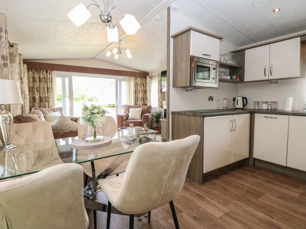 A living room with a dining area and kitchen at The Norfolk Nook 18 Castle Walk Burgh Castle