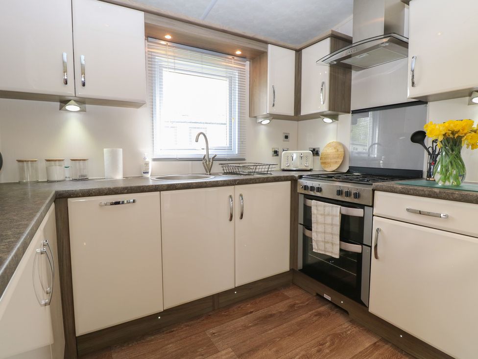 A kitchen with sink and oven at The Norfolk Nook 18 Castle Walk Burgh Castle