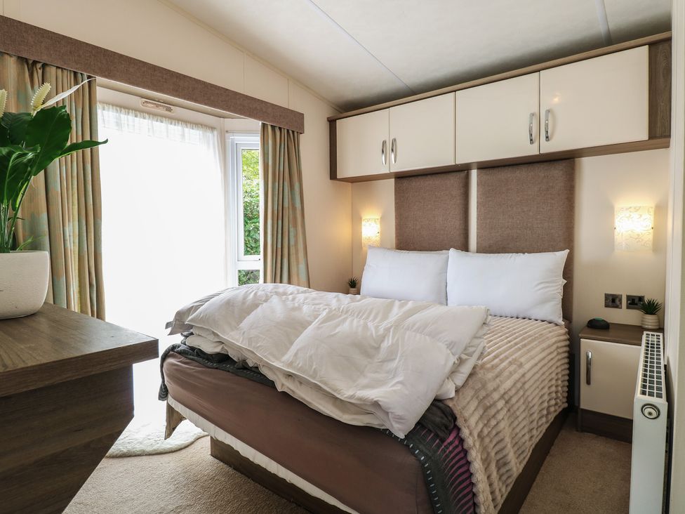 A bedroom with a bed and plant at The Norfolk Nook 18 Castle Walk Burgh Castle