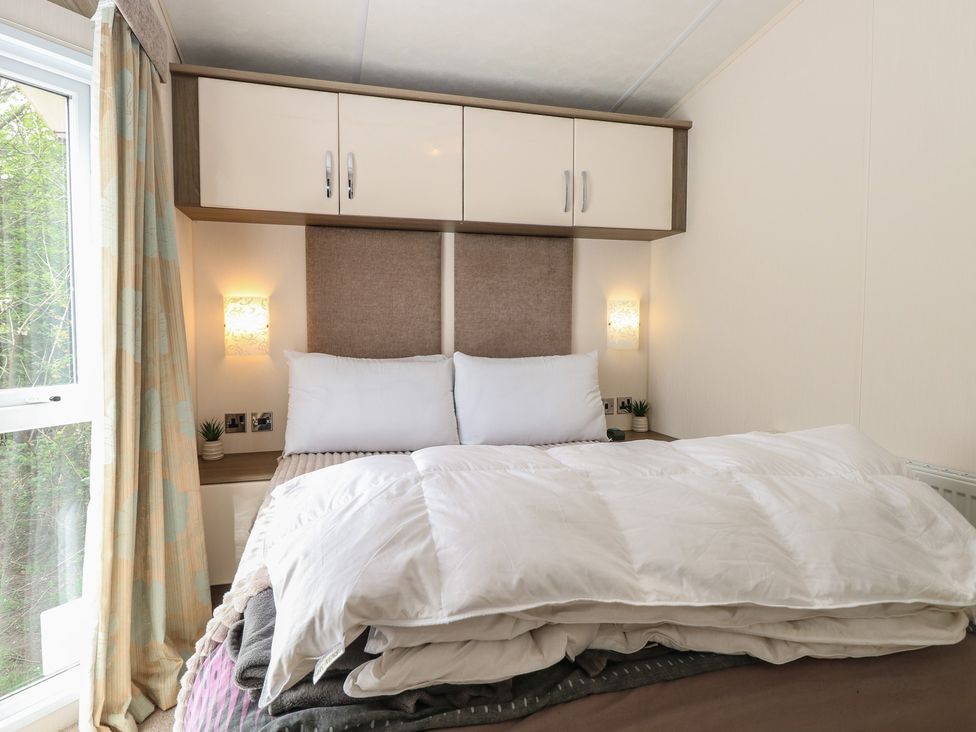 A bedroom with a bed and wardrobe at The Norfolk Nook 18 Castle Walk Burgh Castle