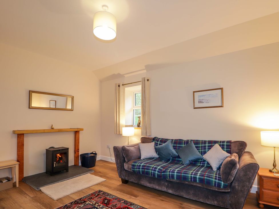 A living room with a sofa and fireplace at Laundry Cottage Strathpeffer