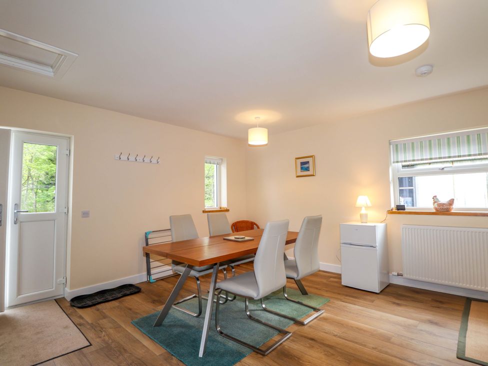 A dining room with a table and chairs at Laundry Cottage in Strathpeffer