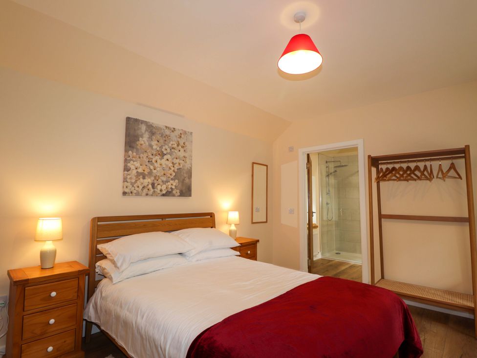 A bedroom with a bed and a wardrobe at Laundry Cottage in Strathpeffer