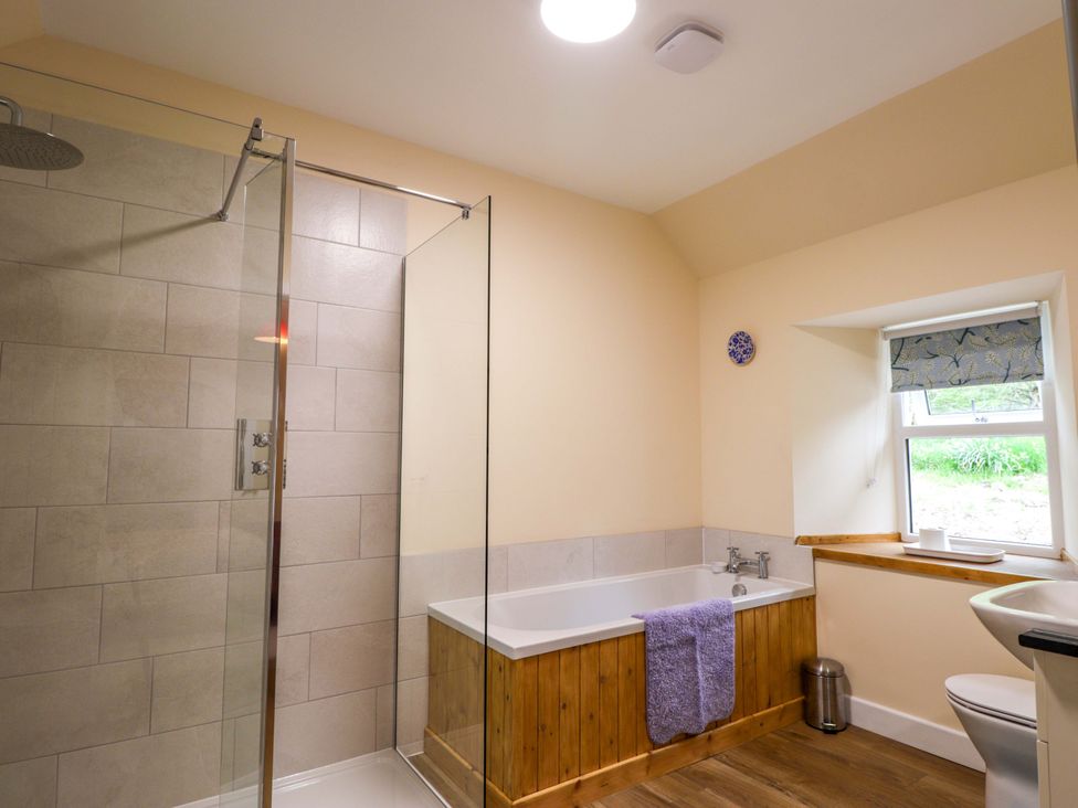 A bathroom with a shower and bathtub at Laundry Cottage in Strathpeffer