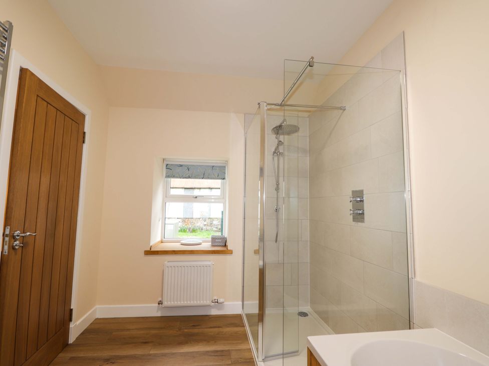 A bathroom with a shower and sink at Laundry Cottage in Strathpeffer