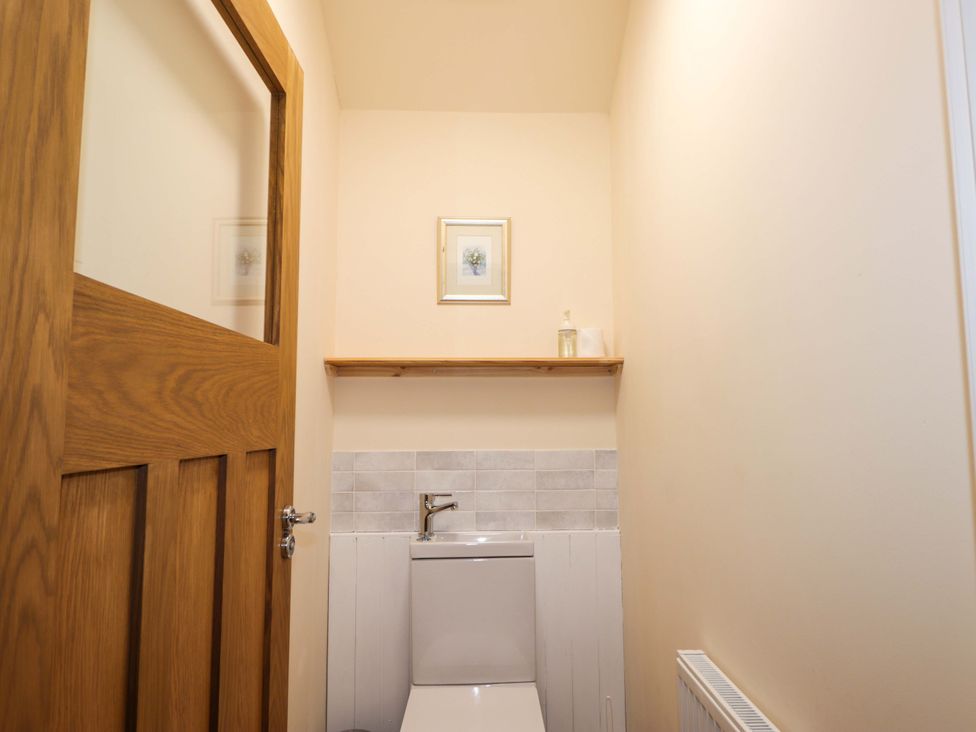 A bathroom with a toilet and sink at Laundry Cottage in Strathpeffer