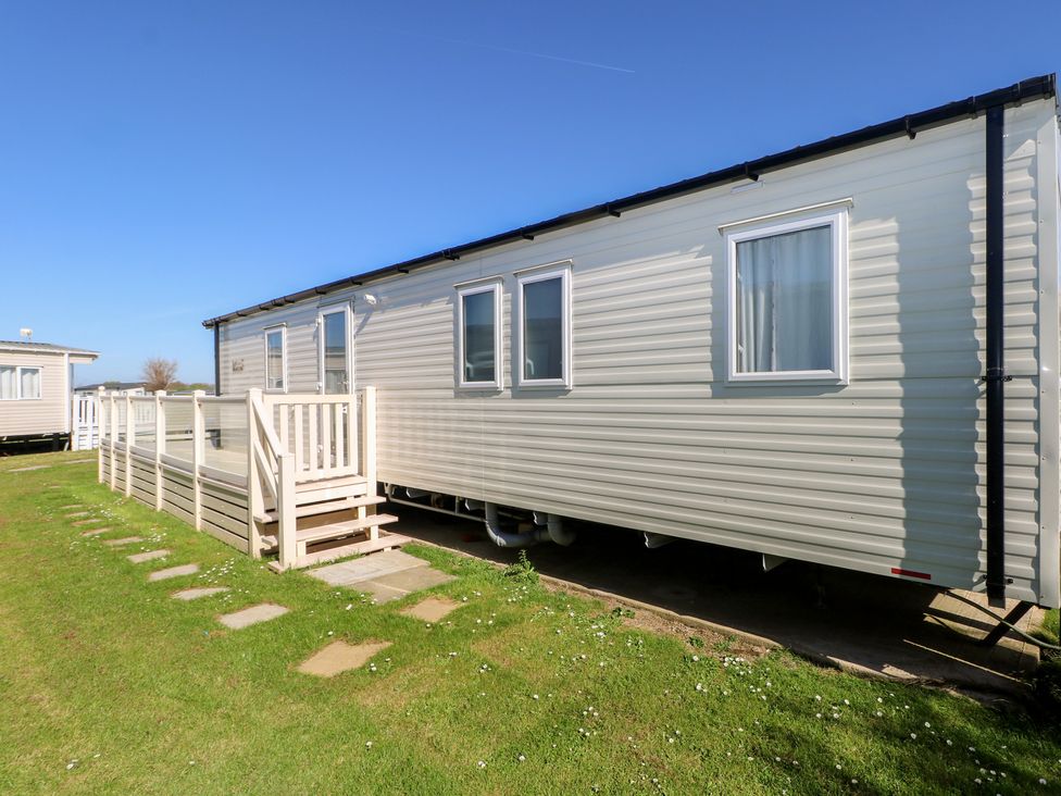 A mobile home with a deck and steps at Seaside Retreat in Selsey