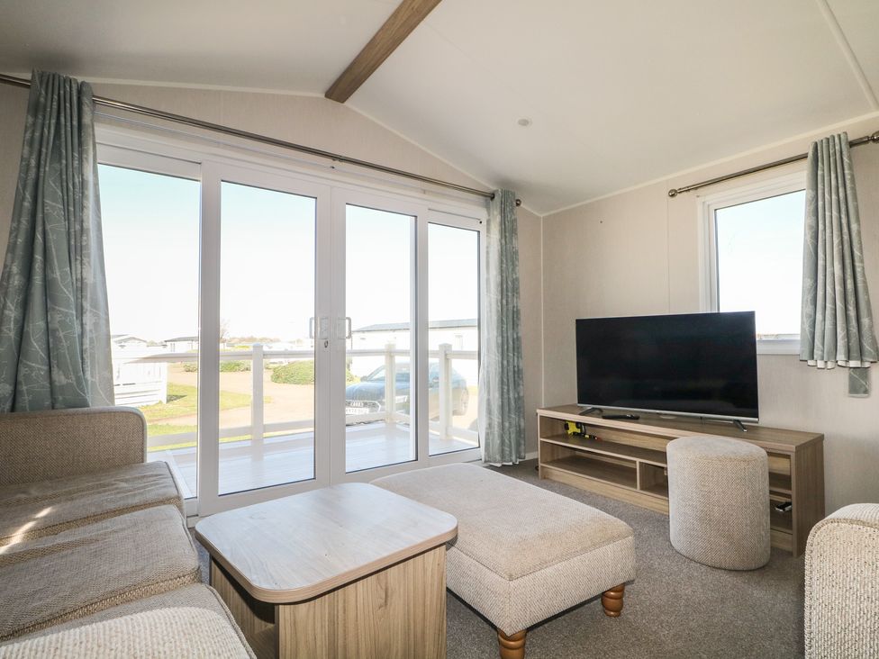 A living room with a television and sofa at Seaside Retreat in Selsey