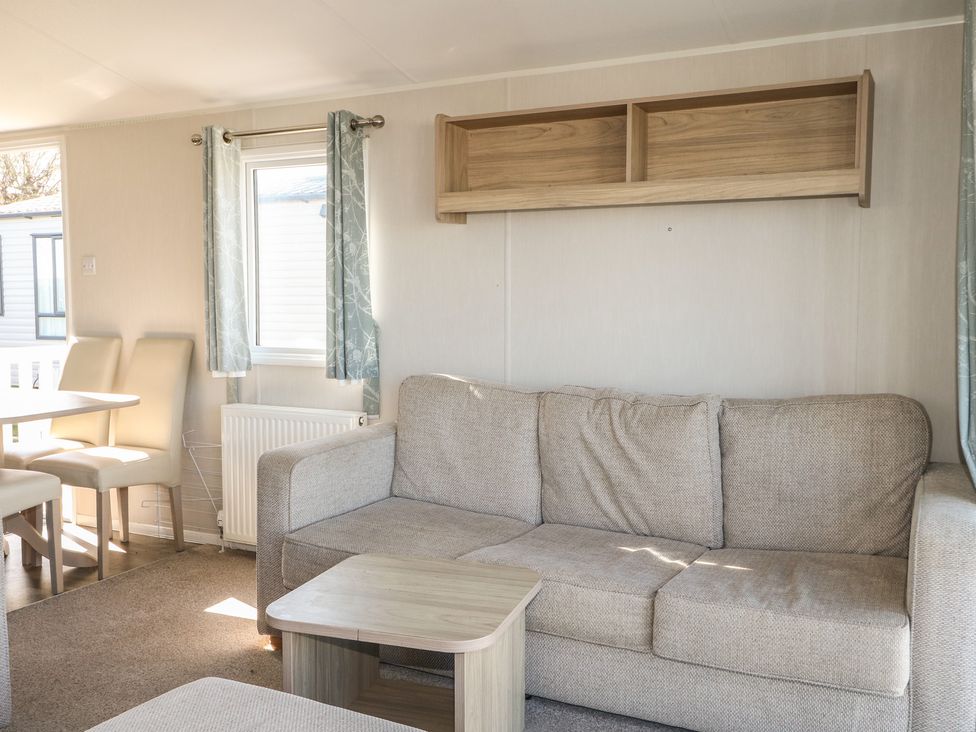 A living room with a sofa and table at Seaside Retreat in Selsey