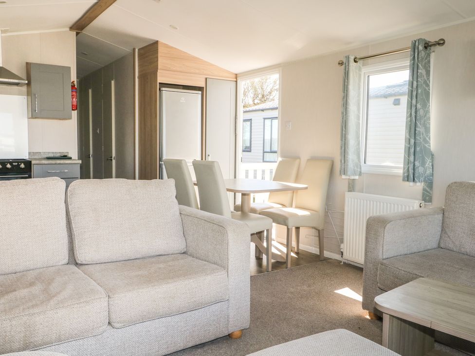 A living room with a sofa and dining area at Seaside Retreat in Selsey