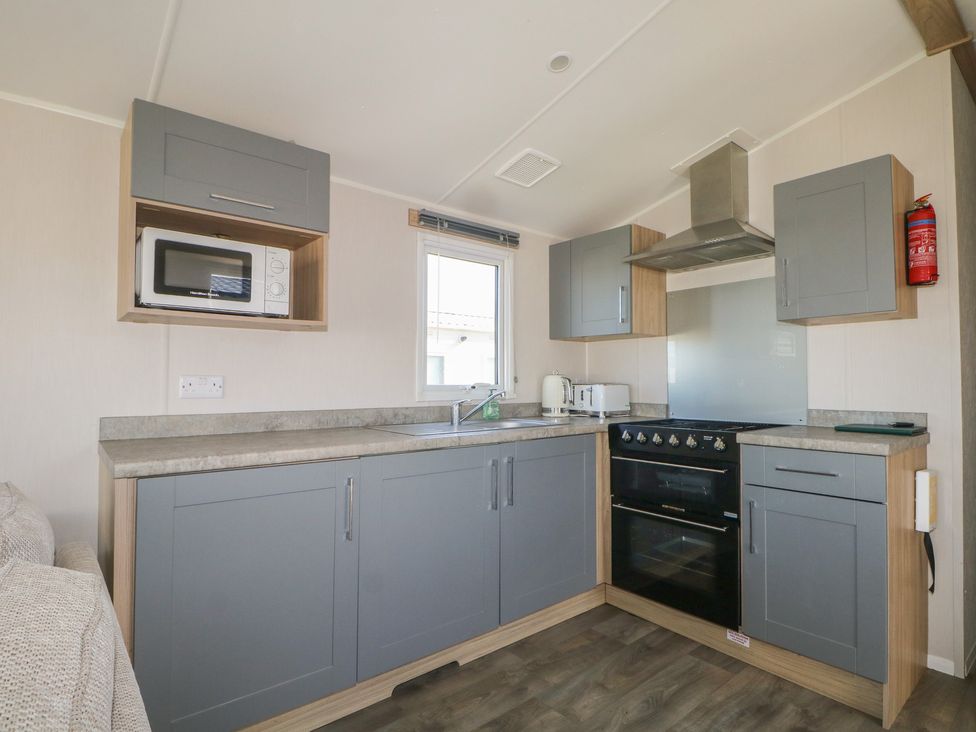 A kitchen with microwave, sink, and oven at Seaside Retreat in Selsey