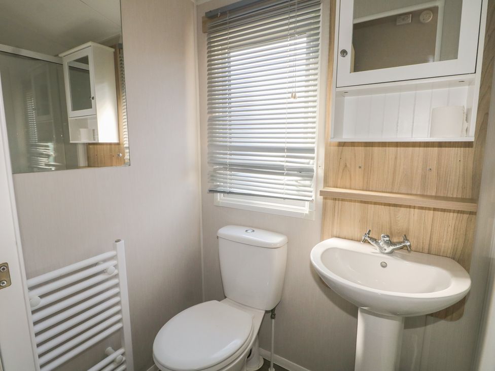 A bathroom with a toilet and sink at Seaside Retreat Selsey