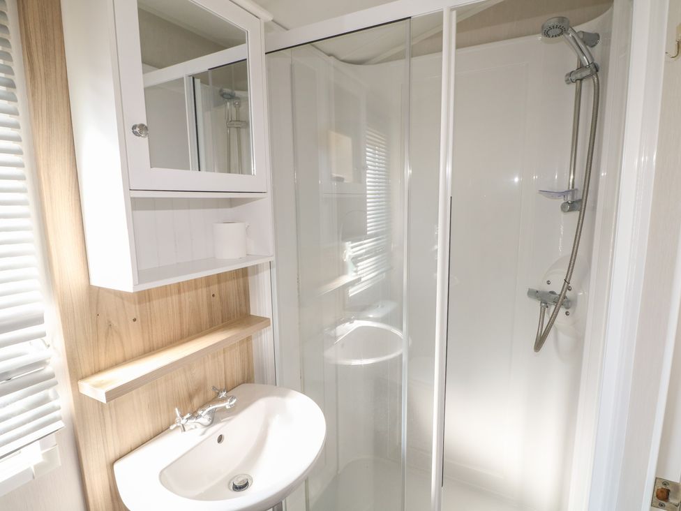 A bathroom with a shower and sink at Seaside Retreat in Selsey