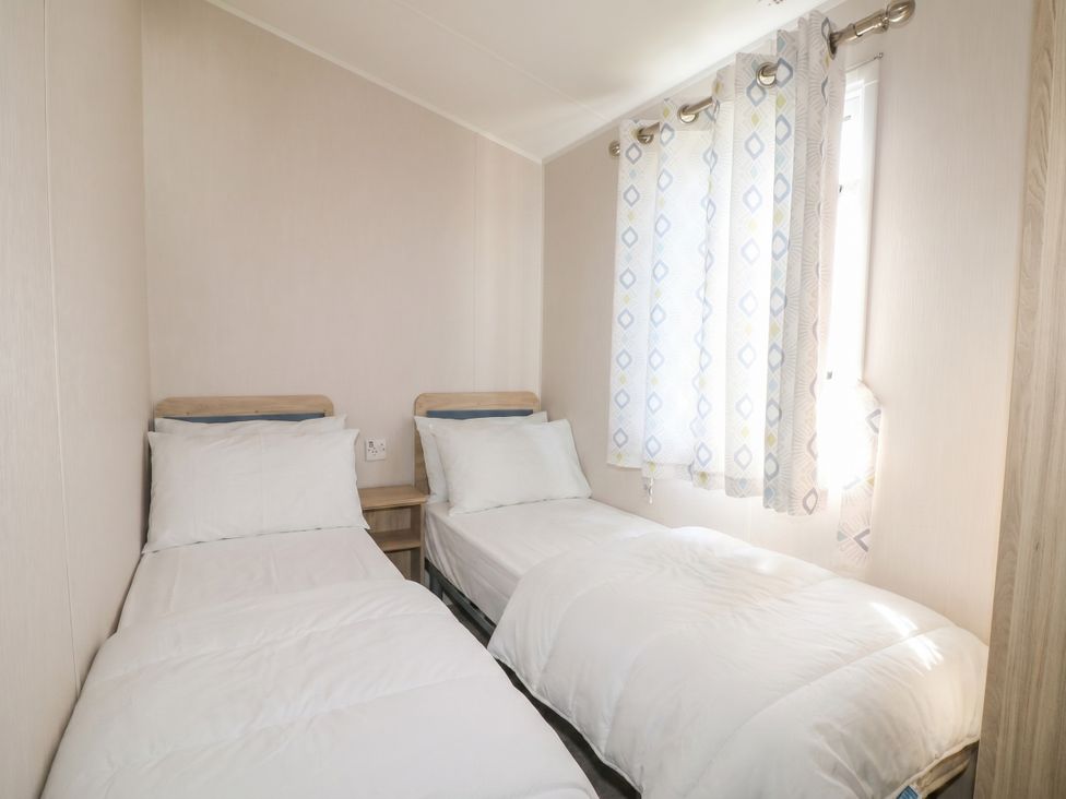 A bedroom with two beds and a window at Seaside Retreat in Selsey