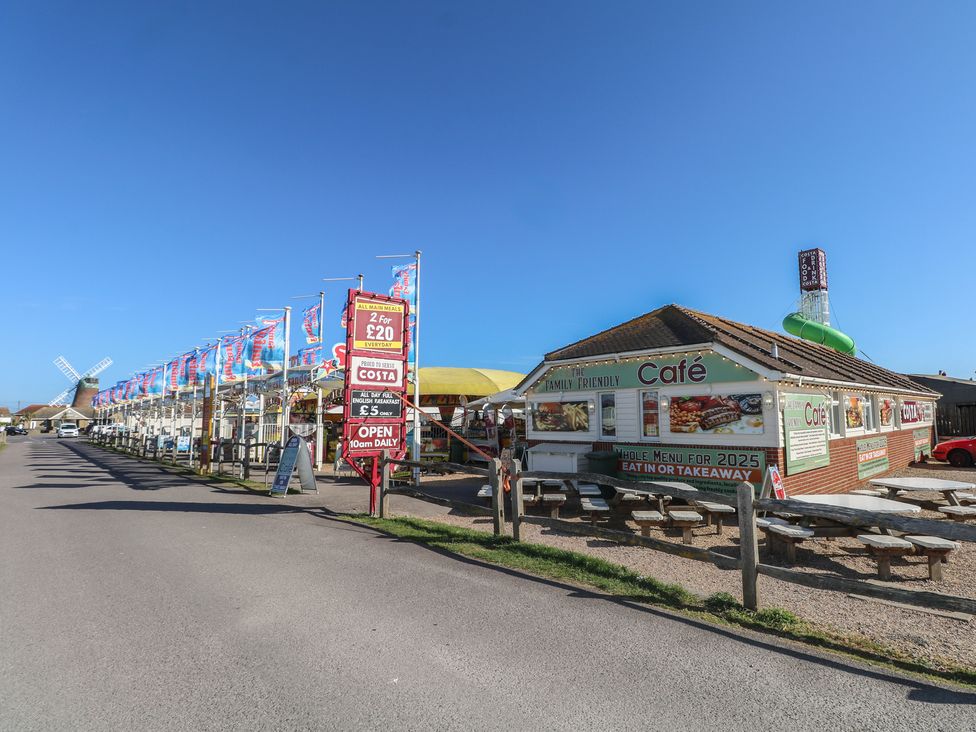 A cafe with outdoor seating and flags at Seaside Retreat in Selsey