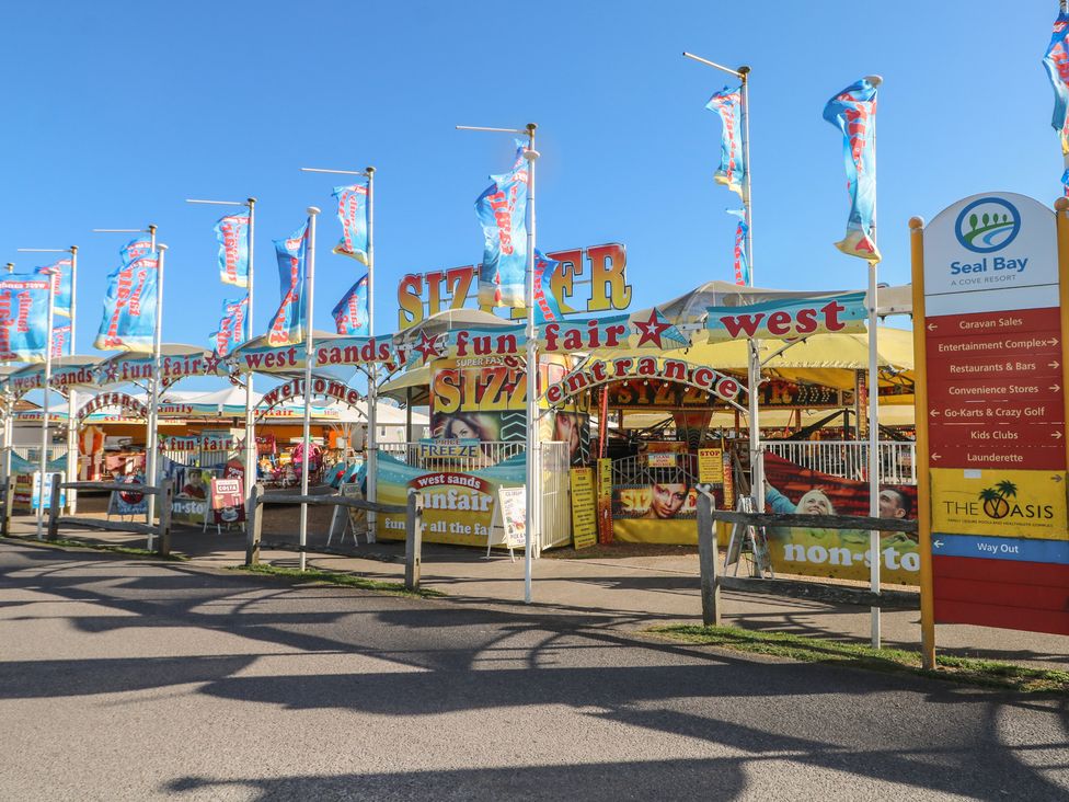 An entrance to a funfair with colorful flags at Seaside Retreat in Selsey