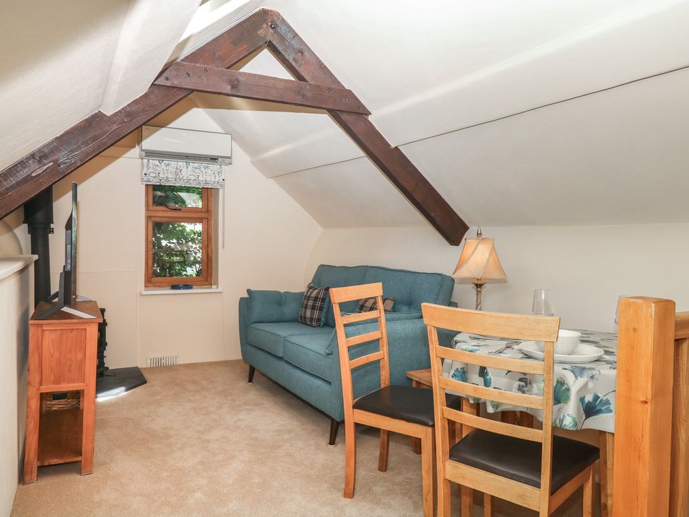 A living room with a sofa, table, and chairs at The Mill Barn in Lustleigh