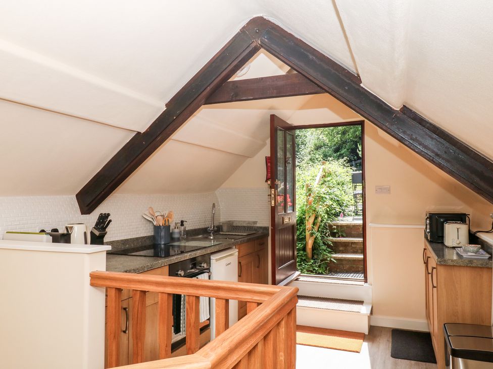A kitchen with countertop and an open door leading outside at The Mill Barn in Lustleigh