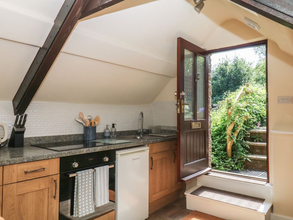 A kitchen with a door leading to stairs at The Mill Barn in Lustleigh
