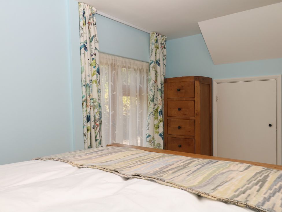 A bedroom with a bed and dresser at The Mill Barn in Lustleigh