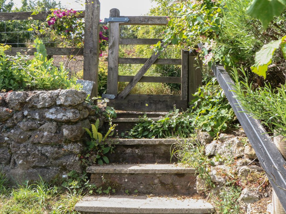 A gate and stone steps leading up to a garden at The Mill Barn in Lustleigh