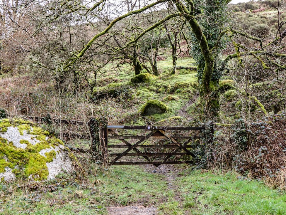 A gate with a path and rocks in a natural setting at The Mill Barn in Lustleigh